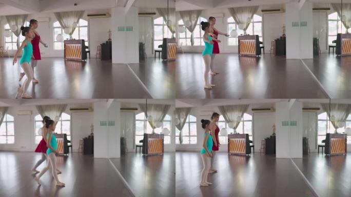 亚洲中国少女芭蕾舞演员面对镜子在工作室训练她的年轻女学生