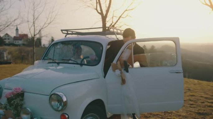 新娘和新郎在日落时坐上老爷车