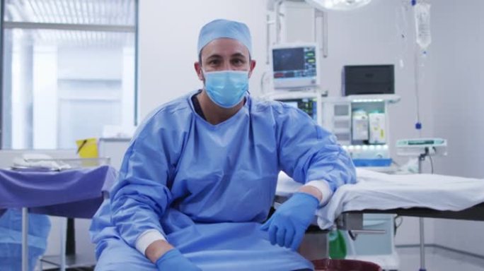 在医院的手术室里戴着口罩的白人男性外科医生的肖像