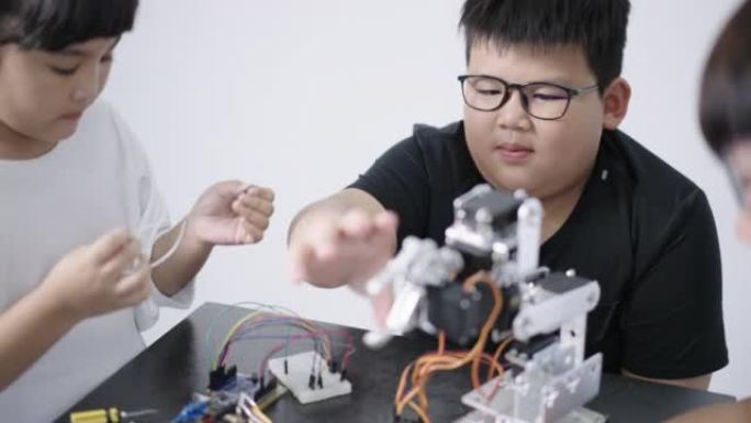 男孩建造和研究机器人STEM编程软件和修复