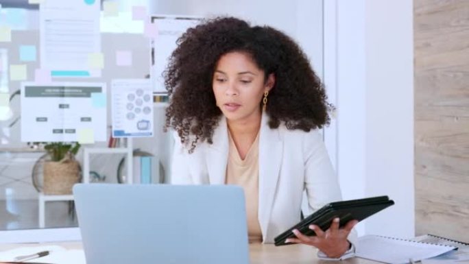 软件分析师在笔记本电脑上打字，并与平板电脑进行比较，同时分析业务或公司信息数据。公司女性从事研究，测