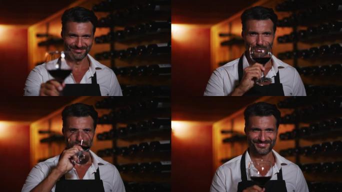 成功成功的男性酿酒师的真实照片正在品尝一种风味，并检查在酒窖中倒入透明玻璃杯中的红酒质量。
