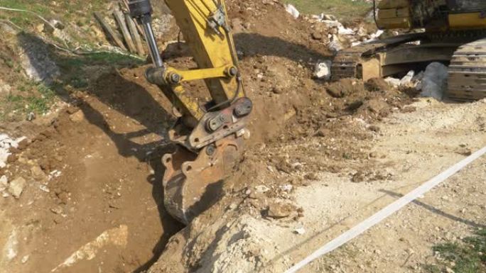 特写: 黄色挖掘机在建筑工地附近挖了一条深沟。