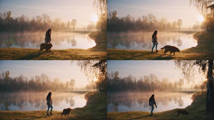 年轻女子带着她的狗沿着雾湖散步