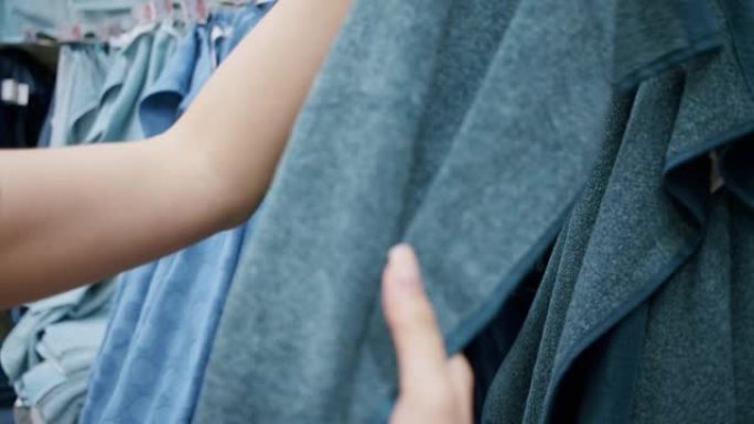 CU女人在家居装饰店的购物架上手工选择现代毛巾。