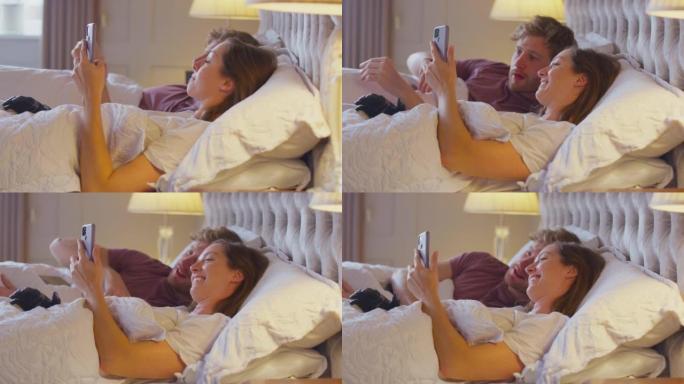 夫妻在床上与假肢的女人一起看着手机-慢动作拍摄