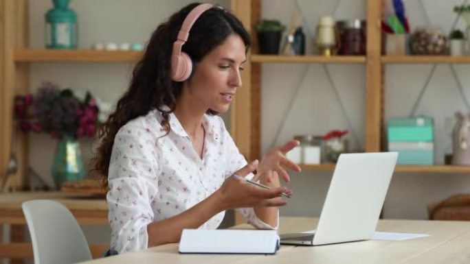 有吸引力的西班牙裔女性使用可视电话和笔记本电脑进行电子学习语言