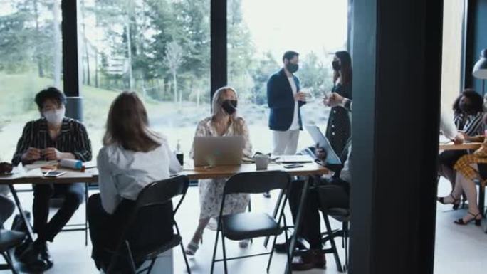 美丽的白人30多岁的老板女商人使用洗手液进入现代轻办公室团队会议慢动作。
