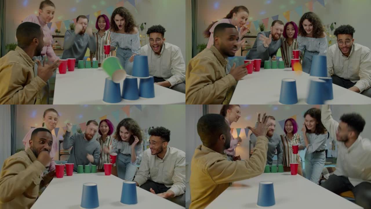 多元化的学生在家庭聚会上玩球游戏大笑