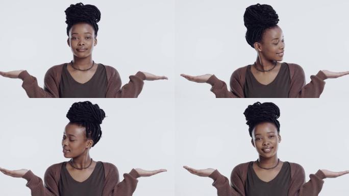 4k视频片段，一名年轻女子站在工作室的白色背景下，在两个选项之间进行选择