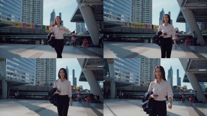 女商人走路和使用智能手机，上下班