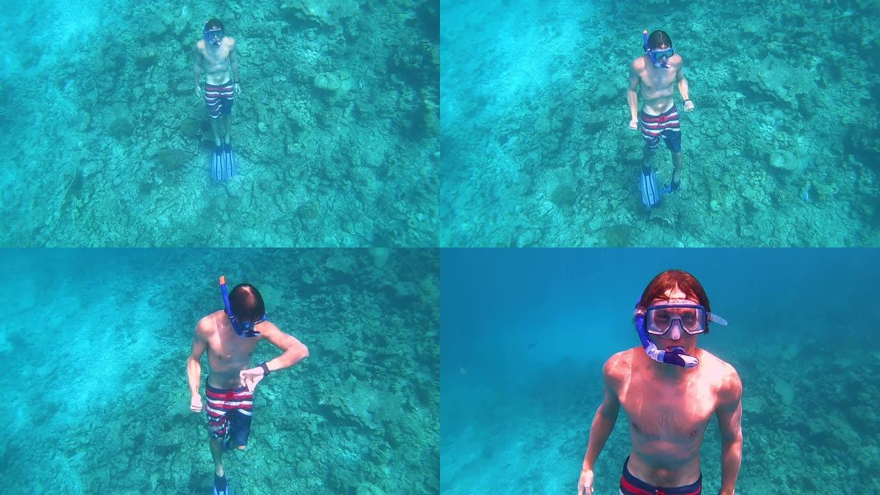 水下: 男性浮潜者从深海上升到深蓝色的海面