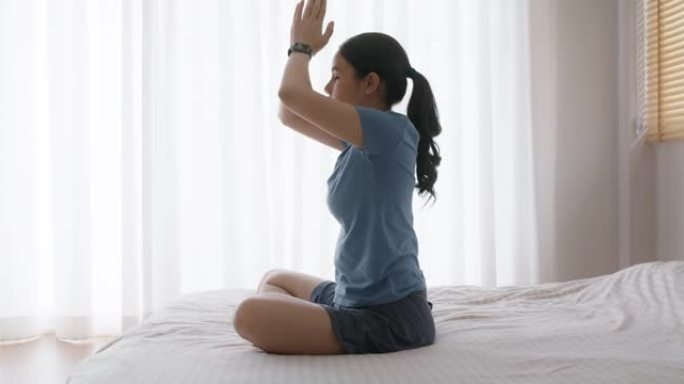 亚洲人早起健康的生活平衡床上瑜伽姿势的好处。