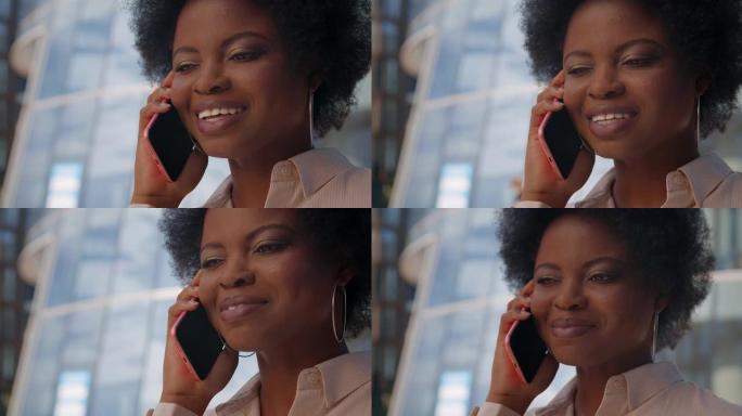 一位深色皮肤的商务女士的特写镜头礼貌地在电话中讲话，背景为现代玻璃结构