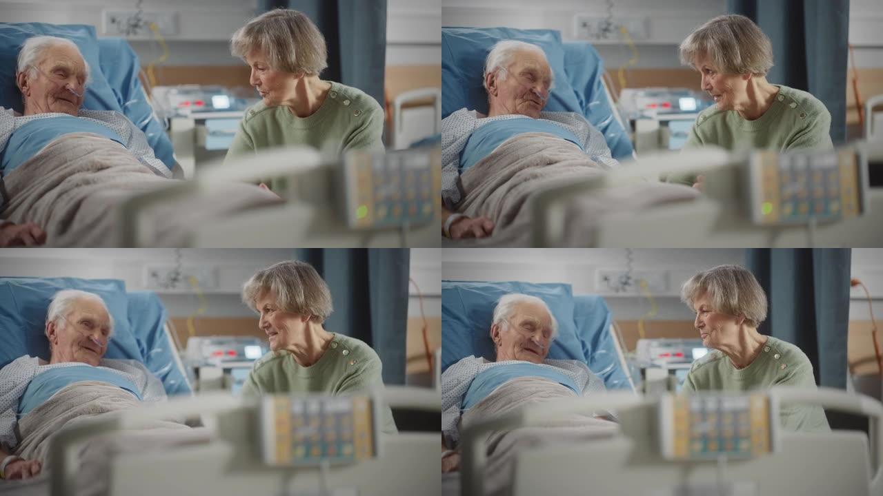 医院病房: 老人躺在床上休息，他有爱心的美丽妻子来访，支持他坐在旁边，手牵着手，幸福的夫妻交谈，微笑