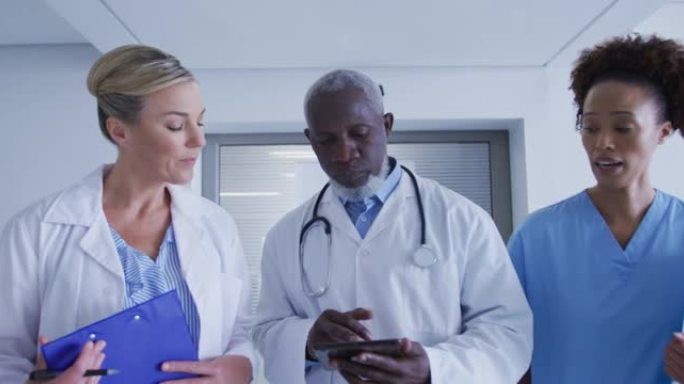 站在医院走廊看平板电脑的男女医生和医务人员