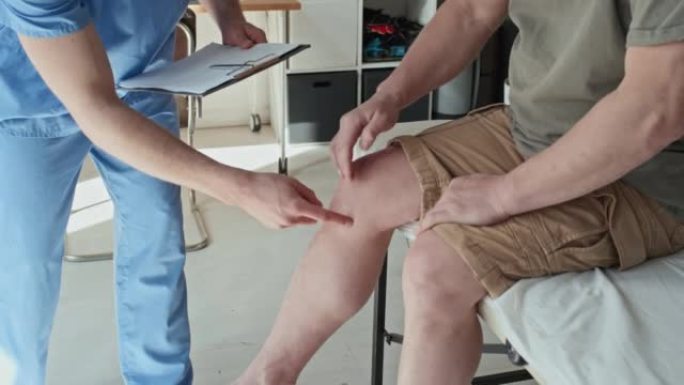 创伤专家检查患者受伤的腿