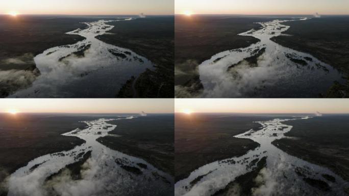 高空日出飞过巨大的赞比西河上的薄雾，流向联合国教科文组织世界遗产维多利亚瀑布