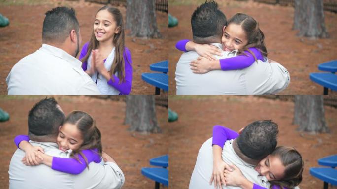 西班牙裔女孩从公园的父亲那里得到了喜讯，拥抱