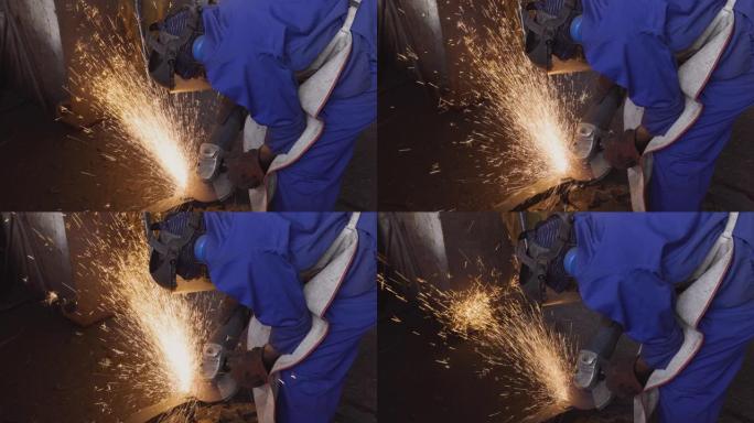 工厂工人使用研磨机研磨在铸造厂铸造的钢制零件上的粗糙边缘
