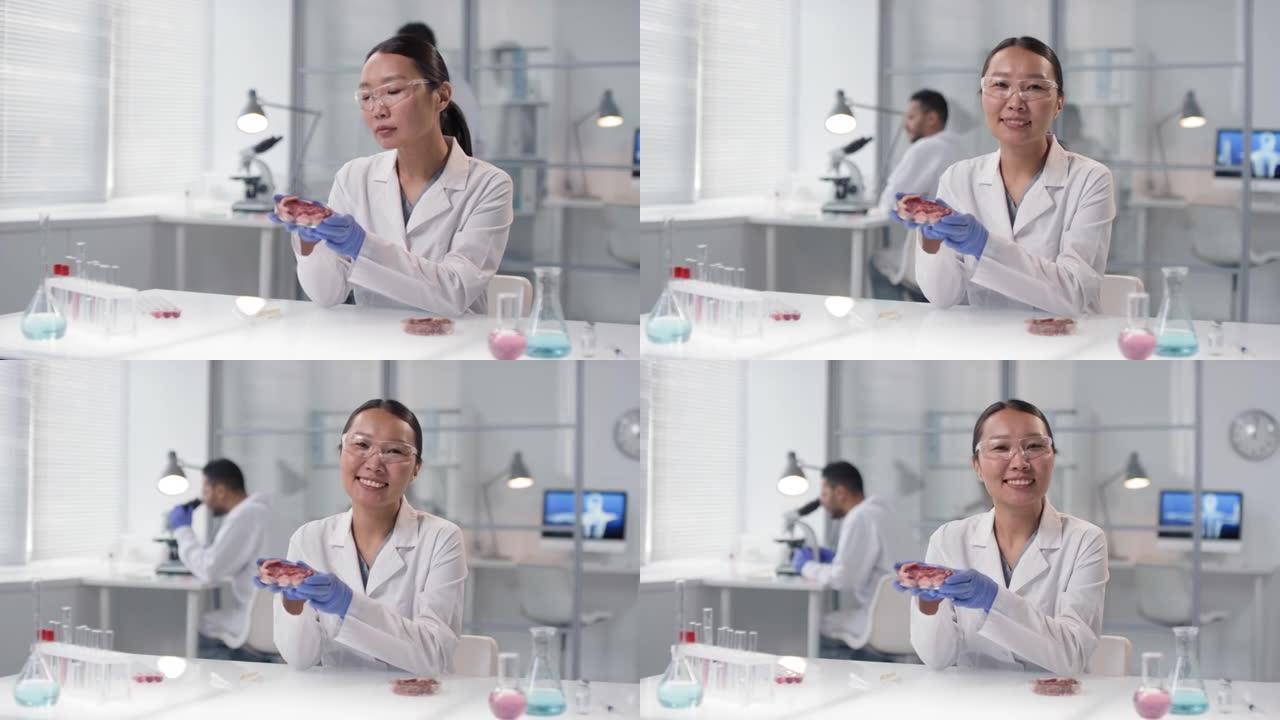 带着肉样本微笑的亚洲女科学家