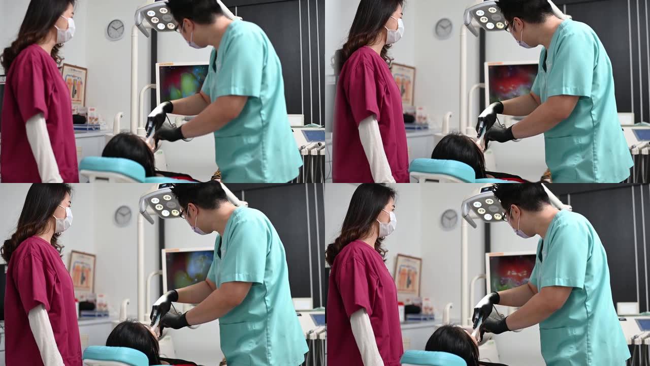 亚洲华人牙医在诊所护士的帮助下为患者进行手术
