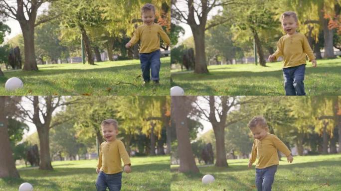 孩子，在户外奔跑，在大自然中与足球一起玩耍，在绿草丛生的树木中感到快乐，嬉戏和精力充沛。小男孩或蹒跚