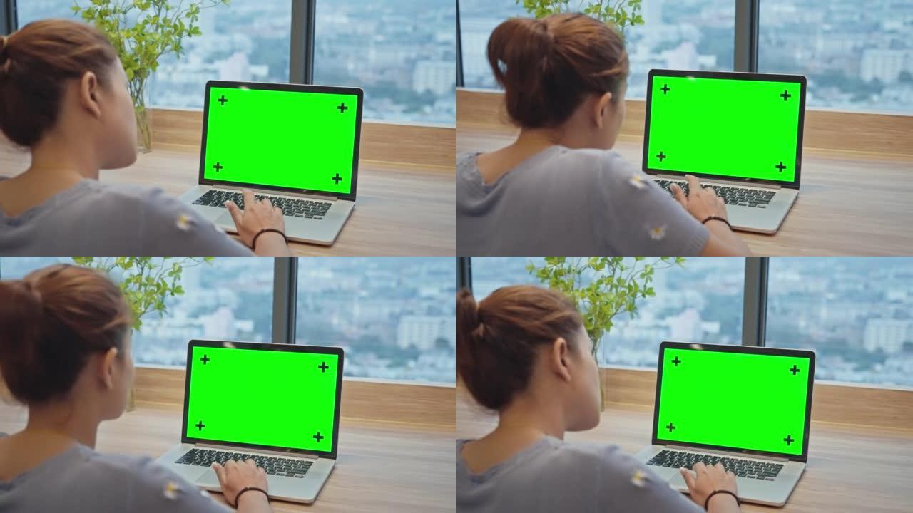现代酒店使用色度键绿屏笔记本电脑的女人