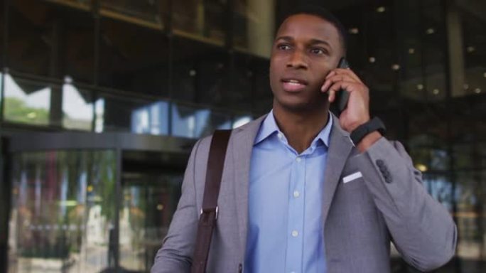 非裔美国商人在现代办公楼外的智能手机上聊天