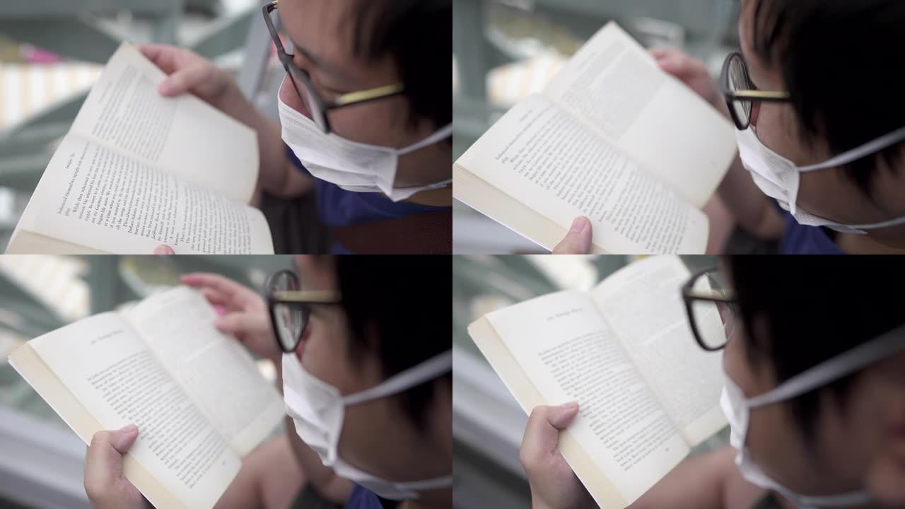 新型冠状病毒肺炎期间戴着眼镜和口罩阅读书籍文学的人。