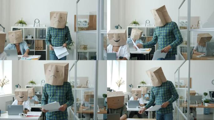 办公室工作人员的纸袋头显示表情符号在办公桌上的项目中工作，而脾气暴躁的老板在给文件
