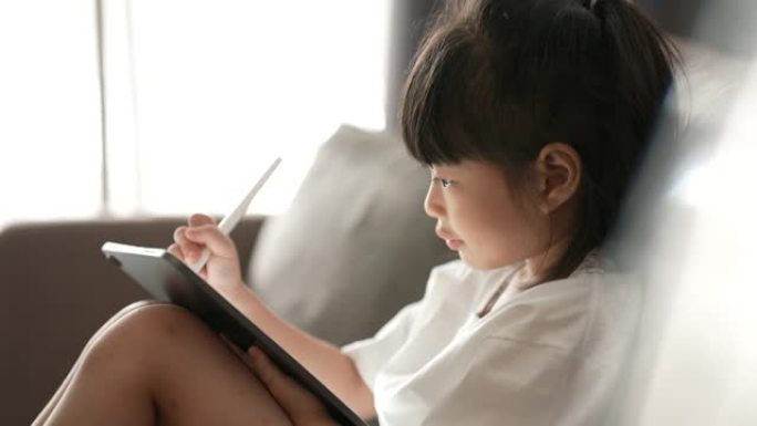 女儿在数字平板电脑上写字从家里到网上上课