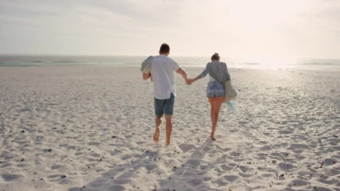 一对年轻夫妇在日落时在海滩上散步的4k视频片段