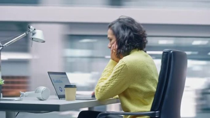 360度延时办公室: 富有成效的拉丁女商人坐在她的办公桌前，在笔记本电脑上工作。微笑着成功的西班牙裔