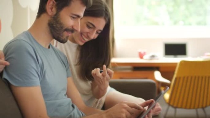 一对年轻夫妇使用数字平板电脑进行在线支付的4k视频片段