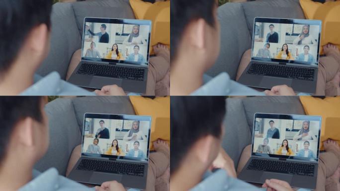 年轻的亚洲商人在客厅在家工作时，使用笔记本电脑与同事讨论视频通话会议的计划。