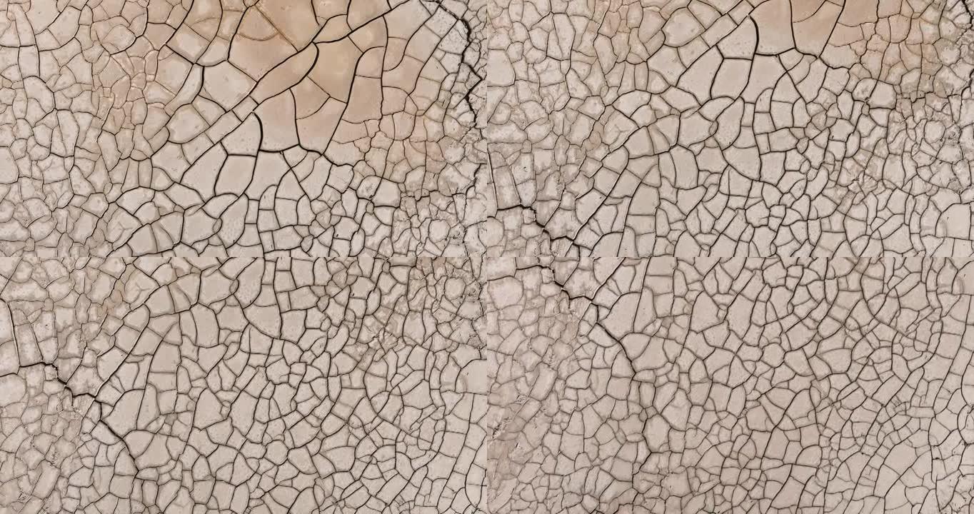 由于气候变化和全球变暖造成的干旱，干旱大坝的图案化开裂的泥浆表面的鸟瞰图