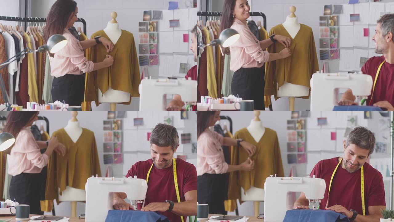 微笑的男女时装设计师与缝纫机一起在工作室工作