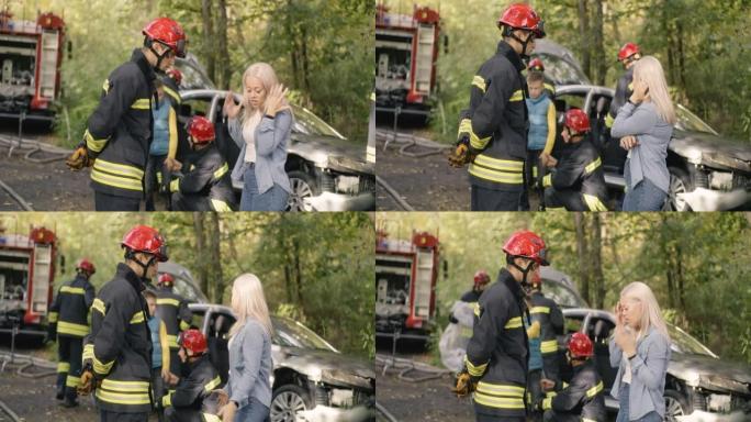 消防员与车祸的女性受害者交谈