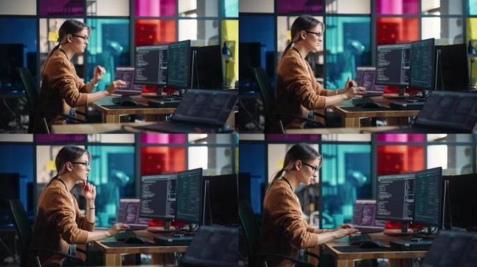 女初级软件工程师在台式计算机上编写代码，在时尚的办公室中放置两台显示器和笔记本电脑。为大型科技公司从
