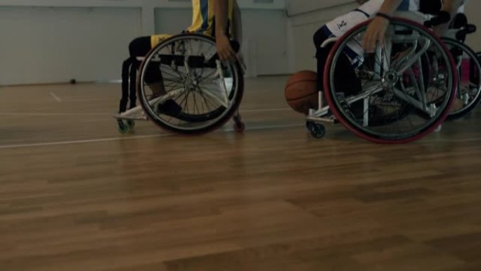男子轮椅篮球队友带球下场。