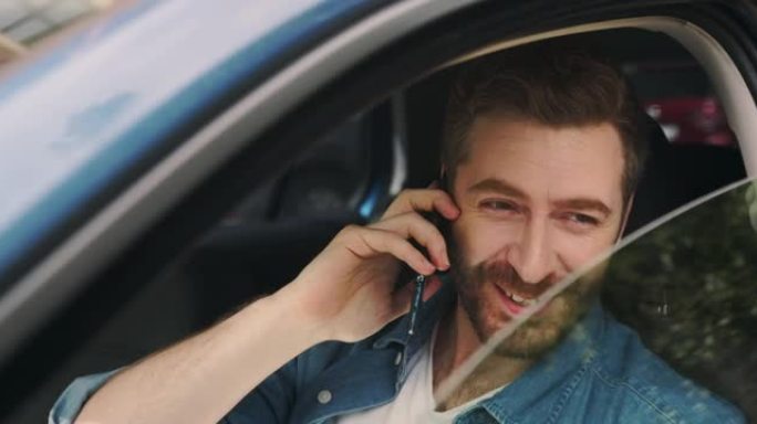 一个年轻的衣着胡须的聪明男人坐在现代汽车上通过电话交谈