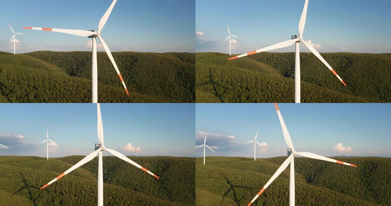 风车的空中特写镜头，风车在风的作用下旋转，并以绿色生态的方式向太阳照耀着地球产生可再生能源。