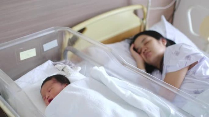 亚洲母亲与新生婴儿在医院睡觉