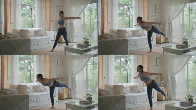 年轻的亚洲妇女在家在客厅练习瑜伽