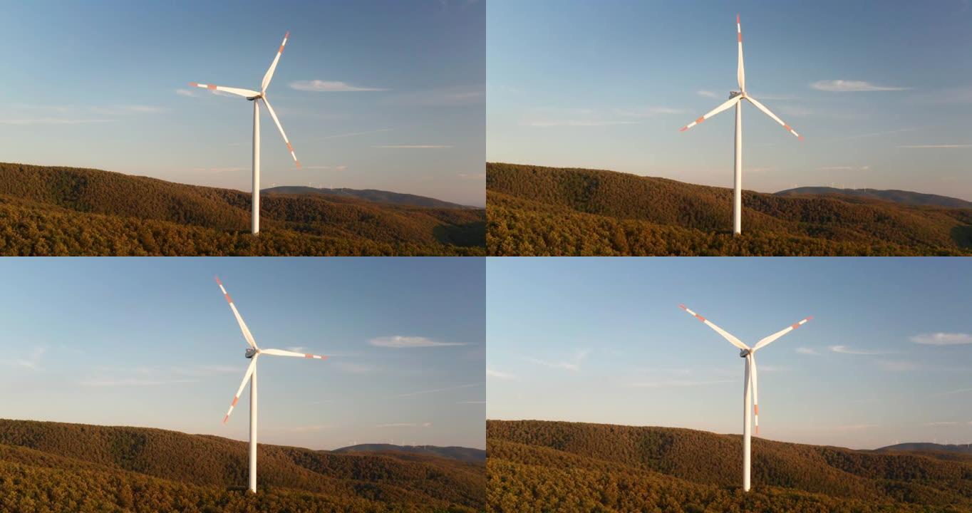 在日落时，风车在风力作用下旋转并以绿色生态方式向地球产生可再生能源的空中特写镜头。