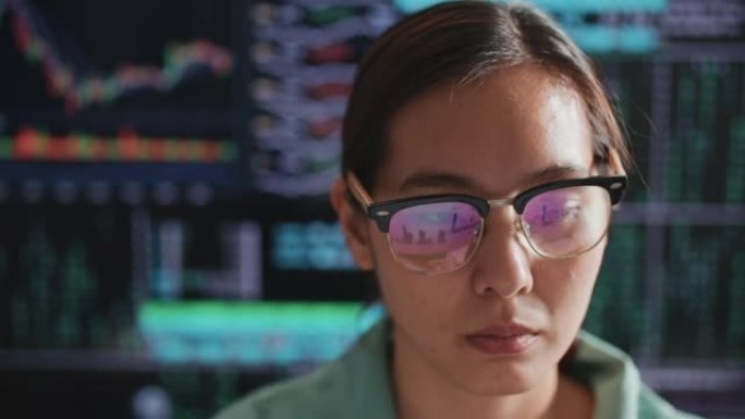 亚洲妇女在大型计算机显示屏或显示器上分析数字，财务数字。