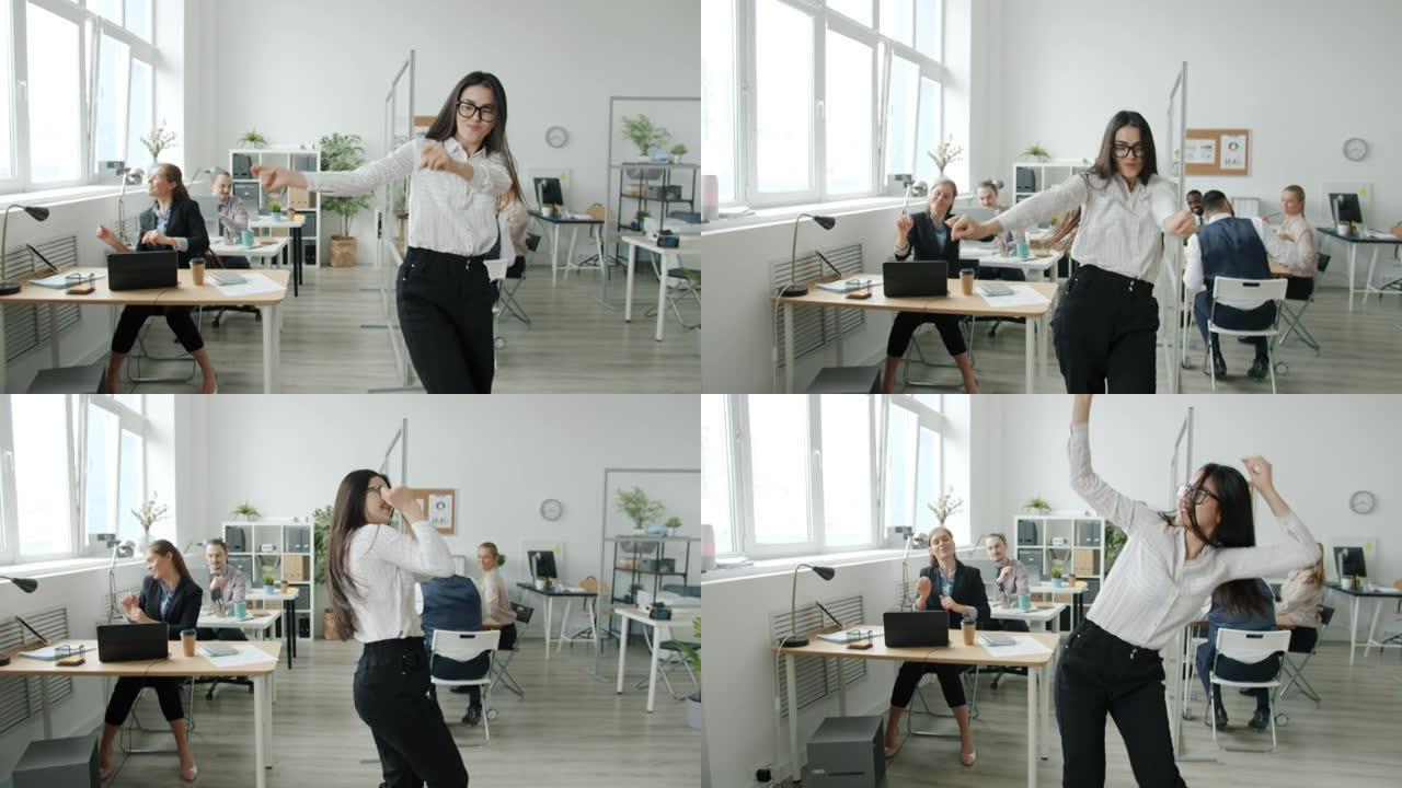 快乐的亚洲女商人在办公室跳舞的慢动作肖像微笑着看着相机