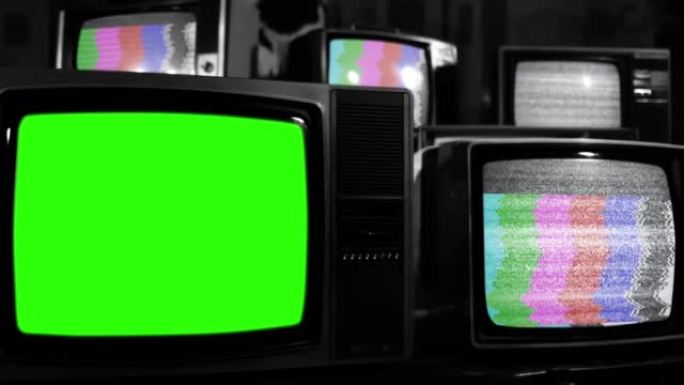 复古电视在许多具有静态噪声和测试图案信号的老式电视中打开色度键绿色屏幕。特写。黑白色调。