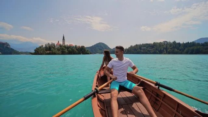 年轻夫妇在美丽的湖上骑着划艇